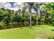 Lush backyard featuring a serene pond, framed by mature trees and manicured lawn, offering a tranquil outdoor retreat at 11121 Clayridge Dr, Tampa, FL 33635