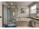 Bathroom featuring a large soaking tub, walk-in shower, tiled floor and walls, and a large window for natural light at 11121 Clayridge Dr, Tampa, FL 33635