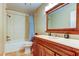 Bathroom featuring a wood vanity, neutral color scheme, tiled floor, and a shower-tub combination with blue curtains at 11121 Clayridge Dr, Tampa, FL 33635
