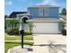 Charming two-story home featuring a manicured lawn, two car garage and vibrant landscaping with palm trees at 11121 Clayridge Dr, Tampa, FL 33635