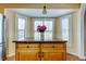 Sunlit kitchen island with granite countertop, maple cabinets and views of the backyard through white plantation shutters at 11121 Clayridge Dr, Tampa, FL 33635