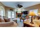Cozy living room with fireplace, ceiling fan, plush seating, and access to the outdoor living space at 11121 Clayridge Dr, Tampa, FL 33635