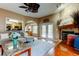 Open-concept living room with a fireplace, access to the kitchen and outdoor pool area at 11121 Clayridge Dr, Tampa, FL 33635