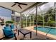 Inviting screened-in patio featuring comfortable seating with a clear view of the pool and lush tropical landscaping at 11121 Clayridge Dr, Tampa, FL 33635