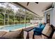 Inviting screened-in patio featuring comfortable seating with a clear view of the pool and lush tropical landscaping at 11121 Clayridge Dr, Tampa, FL 33635