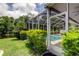 View of screened pool from yard with surrounding greenery, adding to the home's privacy and natural beauty at 11121 Clayridge Dr, Tampa, FL 33635