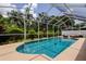 Screened-in pool with clear blue water, surrounded by lush landscaping, providing a private outdoor oasis at 11121 Clayridge Dr, Tampa, FL 33635