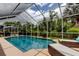 Screened-in pool area showcasing lush landscaping and comfortable lounge chairs, perfect for relaxation and outdoor enjoyment at 11121 Clayridge Dr, Tampa, FL 33635