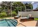 Enclosed pool area featuring stylish wicker lounge chairs and well-maintained landscaping creating a private backyard oasis at 11121 Clayridge Dr, Tampa, FL 33635