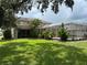 Sprawling backyard featuring manicured lawn, mature landscaping, and screened pool enclosure for outdoor enjoyment at 1178 Fraser Pine Blvd, Sarasota, FL 34240