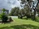 Picture of the backyard with beautiful manicured lawn and lush trees, enclosed with a white fence at 1178 Fraser Pine Blvd, Sarasota, FL 34240
