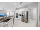 Bright kitchen features stainless steel appliances, white cabinets, and granite countertops, open to the living room at 1178 Fraser Pine Blvd, Sarasota, FL 34240