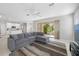 Open-concept living room boasts tile floors, a large gray sectional sofa, and sliding glass doors to the patio at 1178 Fraser Pine Blvd, Sarasota, FL 34240