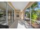 Covered patio with screened enclosure and view of lush tropical landscaping at 1178 Fraser Pine Blvd, Sarasota, FL 34240