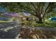 Charming single-story home with lush landscaping, mature trees, a driveway, and a well-maintained lawn at 1207 Oak Valley Dr, Seffner, FL 33584