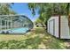 Screened-in pool with backyard shed and plenty of green space for entertaining at 1207 Oak Valley Dr, Seffner, FL 33584