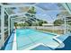 Enclosed pool area with a large pool and patio space, surrounded by lush greenery and a clear blue sky at 1207 Oak Valley Dr, Seffner, FL 33584