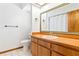 Bright bathroom featuring a wood vanity, large mirror, and tile floors at 12506 Twisted Oak Dr, Tampa, FL 33624