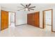 Bright bedroom with ceiling fan, and access to the bathroom with tile floors at 12506 Twisted Oak Dr, Tampa, FL 33624
