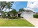 Inviting single-story home boasts a lush green lawn and a convenient two-car garage at 12506 Twisted Oak Dr, Tampa, FL 33624