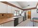 Kitchen featuring tile counters, stainless steel refrigerator, and view of the laundry area at 12506 Twisted Oak Dr, Tampa, FL 33624