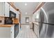 Bright kitchen with stainless steel appliances, tile countertops, and wooden beams at 12506 Twisted Oak Dr, Tampa, FL 33624