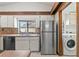 Bright kitchen with stainless steel appliances, tile countertops, and view into the laundry room at 12506 Twisted Oak Dr, Tampa, FL 33624