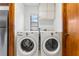 Bright laundry room featuring a wooden door and white washer and dryer units at 12506 Twisted Oak Dr, Tampa, FL 33624