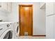 Laundry room featuring a wooden door with a pet access and white washer and dryer units at 12506 Twisted Oak Dr, Tampa, FL 33624
