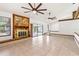 Spacious living room with a stone fireplace, ceiling fans, and sliding doors to a screened-in patio at 12506 Twisted Oak Dr, Tampa, FL 33624