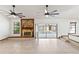 Open-plan living room featuring a stone fireplace, two ceiling fans and sliding glass doors to the outside at 12506 Twisted Oak Dr, Tampa, FL 33624
