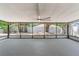 A screened lanai with a ceiling fan offers a relaxing view of the fenced backyard at 12506 Twisted Oak Dr, Tampa, FL 33624