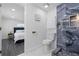 Bathroom with marble tiled shower, gold fixtures, and a view into a bedroom from the toilet at 1413 E 108Th Ave, Tampa, FL 33612