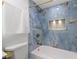 Bathroom showing a marble tiled shower with gold fixtures and a modern built-in shelf at 1413 E 108Th Ave, Tampa, FL 33612