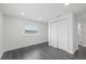 Bright bedroom featuring gray laminate flooring, window, and double closet for storage at 1413 E 108Th Ave, Tampa, FL 33612