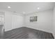 Bright bedroom featuring gray laminate flooring, window, and double closet for storage at 1413 E 108Th Ave, Tampa, FL 33612