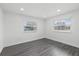 Bright, empty bedroom showcasing two windows offering plenty of natural light and gray laminate flooring at 1413 E 108Th Ave, Tampa, FL 33612