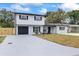 Charming two-story home featuring a fresh exterior paint job, a black garage door and new landscaping at 1413 E 108Th Ave, Tampa, FL 33612