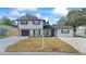 Charming two-story home featuring a fresh exterior paint job, a black garage door and new landscaping at 1413 E 108Th Ave, Tampa, FL 33612