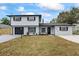 Two-story home featuring black trim, a black garage door, new landscaping, and a well-manicured lawn at 1413 E 108Th Ave, Tampa, FL 33612