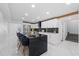 Open kitchen layout showcasing stainless steel appliances, a black countertop island, and modern white cabinets at 1413 E 108Th Ave, Tampa, FL 33612