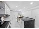Bright kitchen featuring a central island with black countertop, brass sink, and stylish white cabinetry at 1413 E 108Th Ave, Tampa, FL 33612