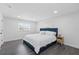Spacious bedroom featuring a plush bed, gray laminate flooring, and plenty of natural light at 1413 E 108Th Ave, Tampa, FL 33612