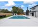 View of backyard with pool, grass, dining set, shed, and fenced perimeter at 1413 E 108Th Ave, Tampa, FL 33612