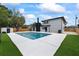 Backyard boasts a sparkling pool, white concrete pool deck, and black brick chimney at 1413 E 108Th Ave, Tampa, FL 33612