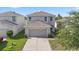 Aerial view of a two-story home with a two-car garage and a well-manicured lawn at 14403 Dunrobin Dr, Wimauma, FL 33598