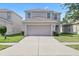 Charming two-story home features a two-car garage, well-maintained lawn, and neutral color scheme at 14403 Dunrobin Dr, Wimauma, FL 33598