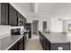 Modern kitchen featuring stainless steel appliances, granite countertops, and dark wood cabinetry at 14403 Dunrobin Dr, Wimauma, FL 33598