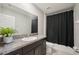 Well-lit bathroom with granite countertops, vanity, mirror, and shower featuring a black curtain at 14460 English Lavender Dr, Wimauma, FL 33598
