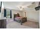 Cozy bedroom featuring a queen-size bed with a stylish headboard and a window offering natural light at 14460 English Lavender Dr, Wimauma, FL 33598